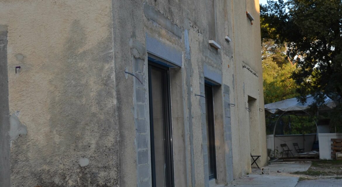 Dans la commune de Mornas, au pied de son imposante forteresse médiévale, une rénovation de façade a été menée pour redonner tout son éclat à une habitation. Ce projet s’est distingué par un enduit mixte, combinant un effet pierre authentique et un rendu lisse couleur sable, afin de préserver le cachet du bâti tout en lui apportant une protection optimale contre les agressions extérieures. L’objectif de cette intervention était double : sublimer l’architecture de la maison en jouant sur les textures et harmoniser la façade avec l’environnement provençal. Grâce à un travail méticuleux et un choix de matériaux adaptés, ce ravalement a permis d’offrir un résultat esthétique et durable. Retour sur les étapes clés de cette réalisation.